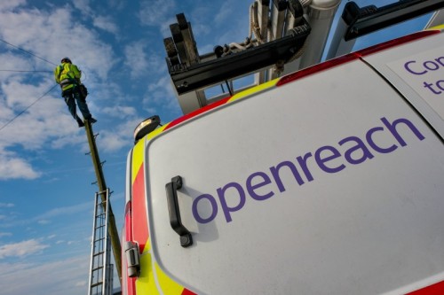 A close-up image of the back of an Openreach van. An Openreach engineer is working on a telephone pole in the background.
